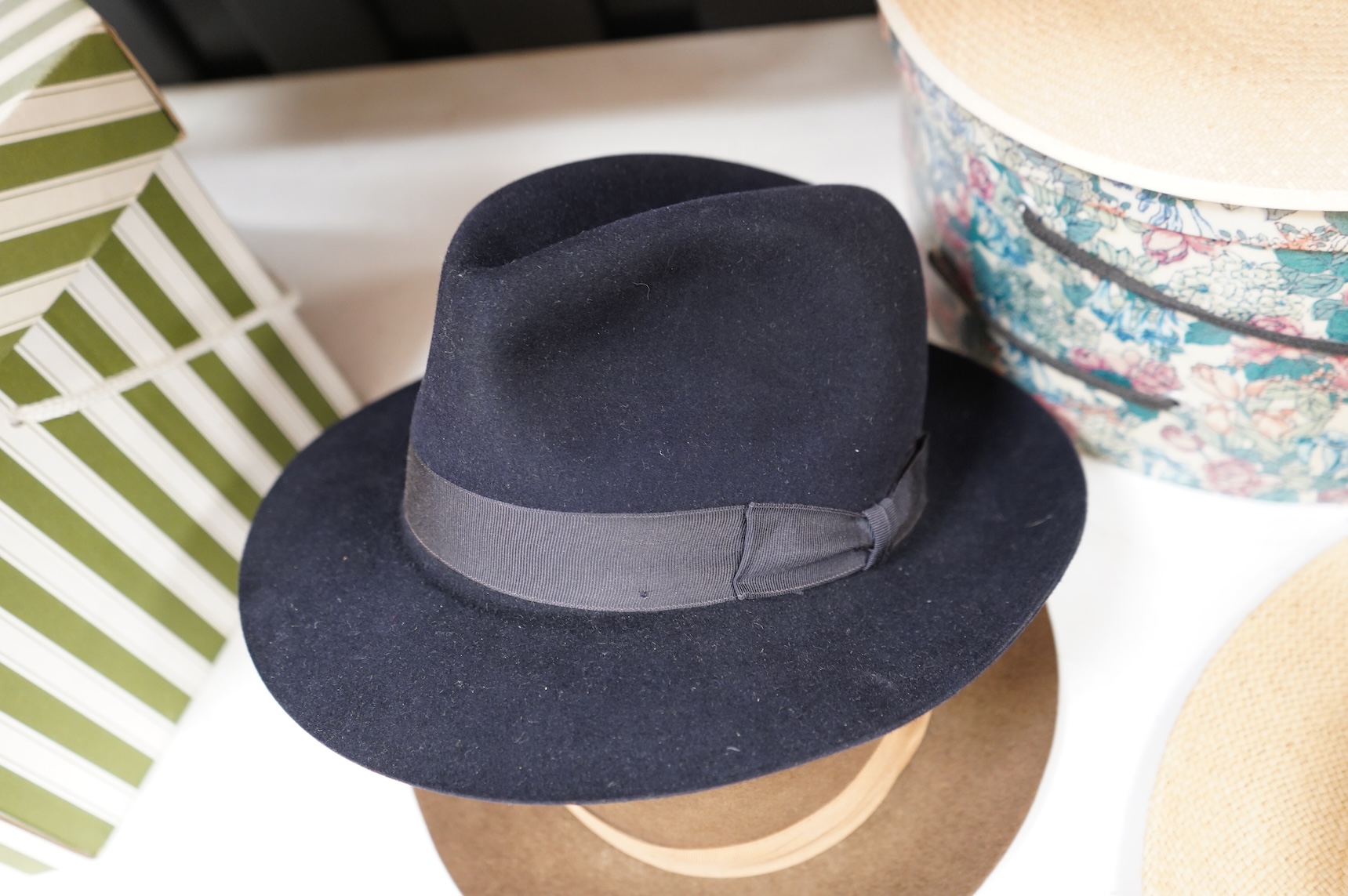 Two hat boxes containing five gentleman's hats; three Fedoras by Locke, Christy’s and Herbert Johnson and two straw Panamas, one by Bates.